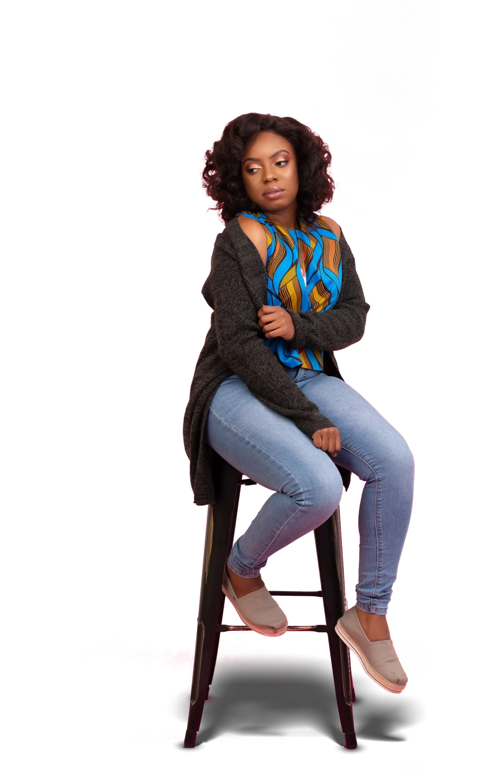 Shurnelle seated on a stool in a colorful blouse